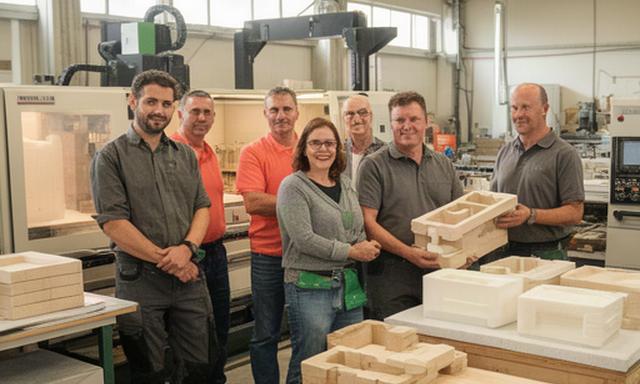 Mitarbeitende von P.S. Nashorn Hülle GmbH gemeinsam in der Werkstatt in Eschenbach, zwischen Maschinen und gefertigten Schutzverpackungen